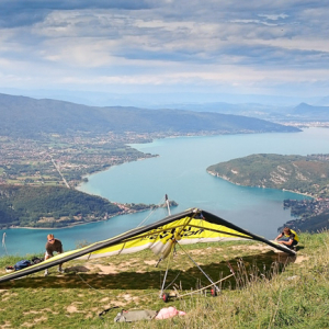 Montmin (Francja), 12.09.2015. Lotniarz w trakcie przygotowywania siÄ™ do lotu tandemowego na tle jeziora Jezioro Annecy